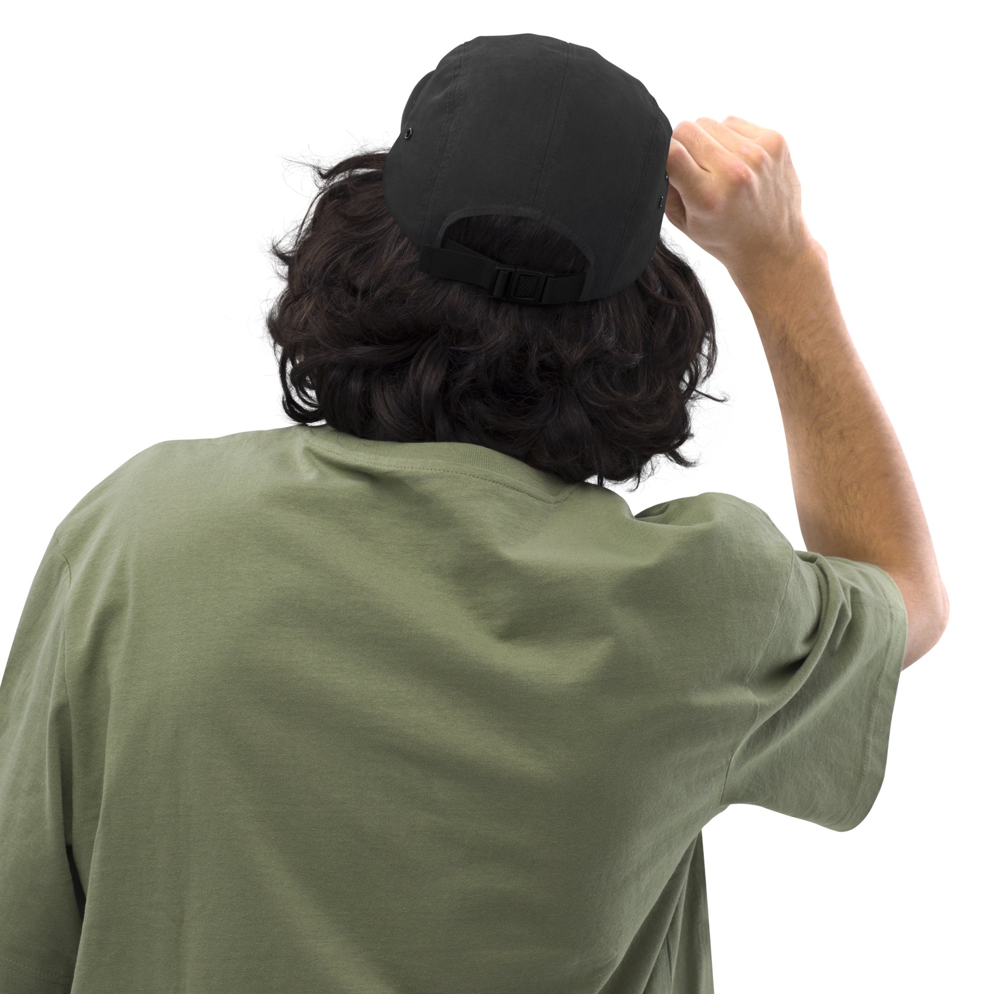Rear view of person with curly black hair wearing black 5-panel cap and olive green t-shirt