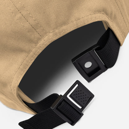 Close-up of khaki 5-panel cap with black adjustable strap and plastic buckle