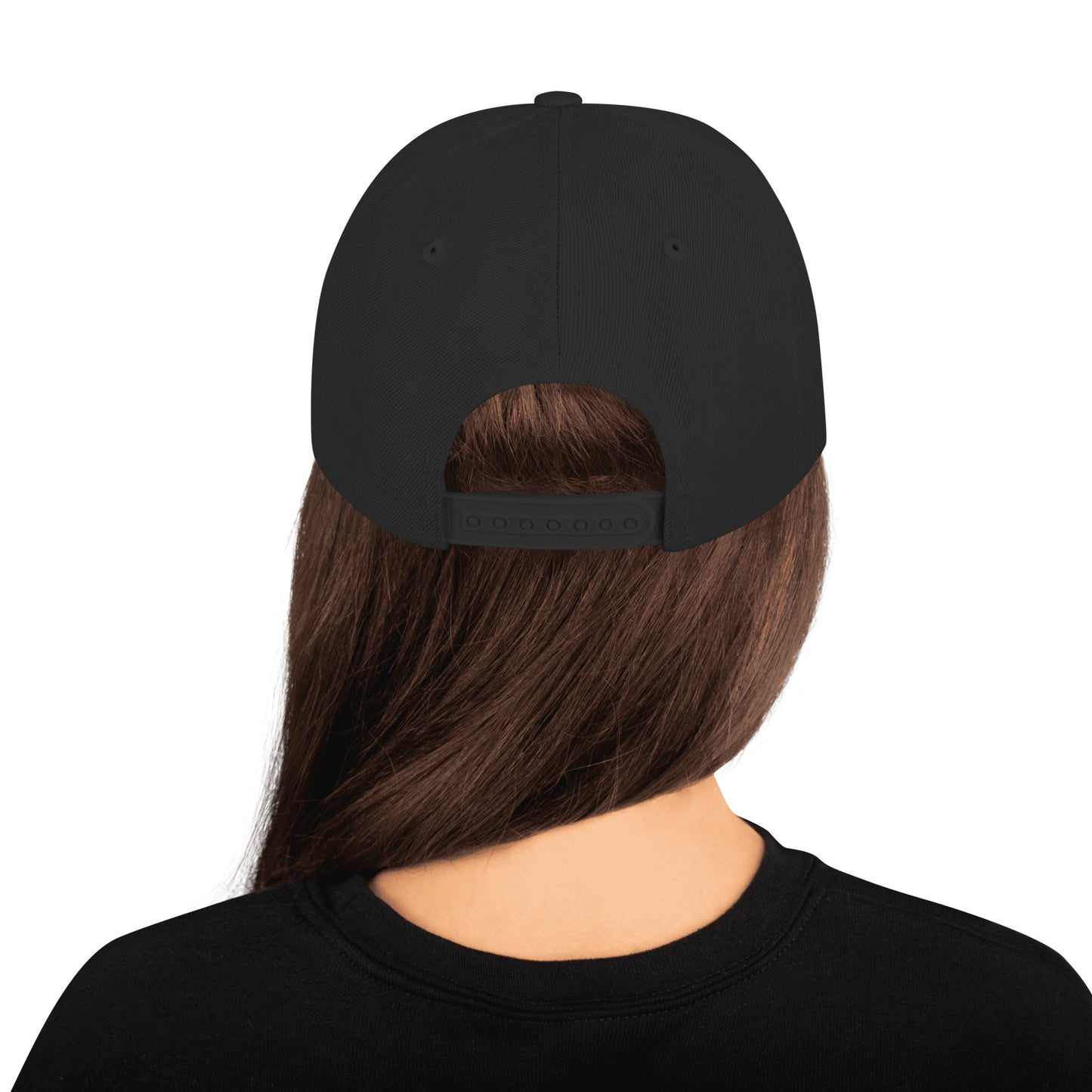 Back view of person with long brown hair wearing a black classic snapback cap and black shirt