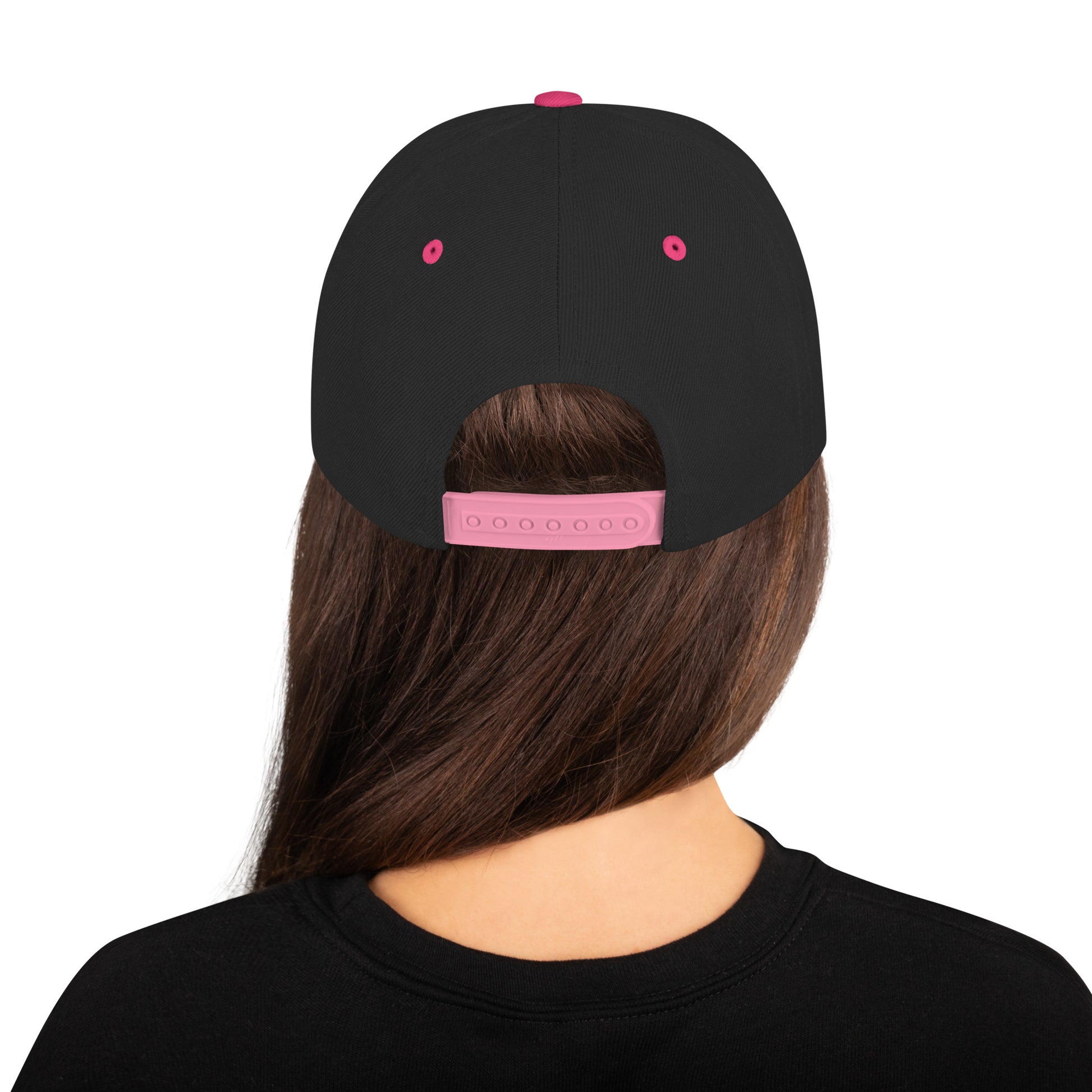 Back view of a person with long brown hair wearing a black snapback hat with neon pink adjustable strap and details