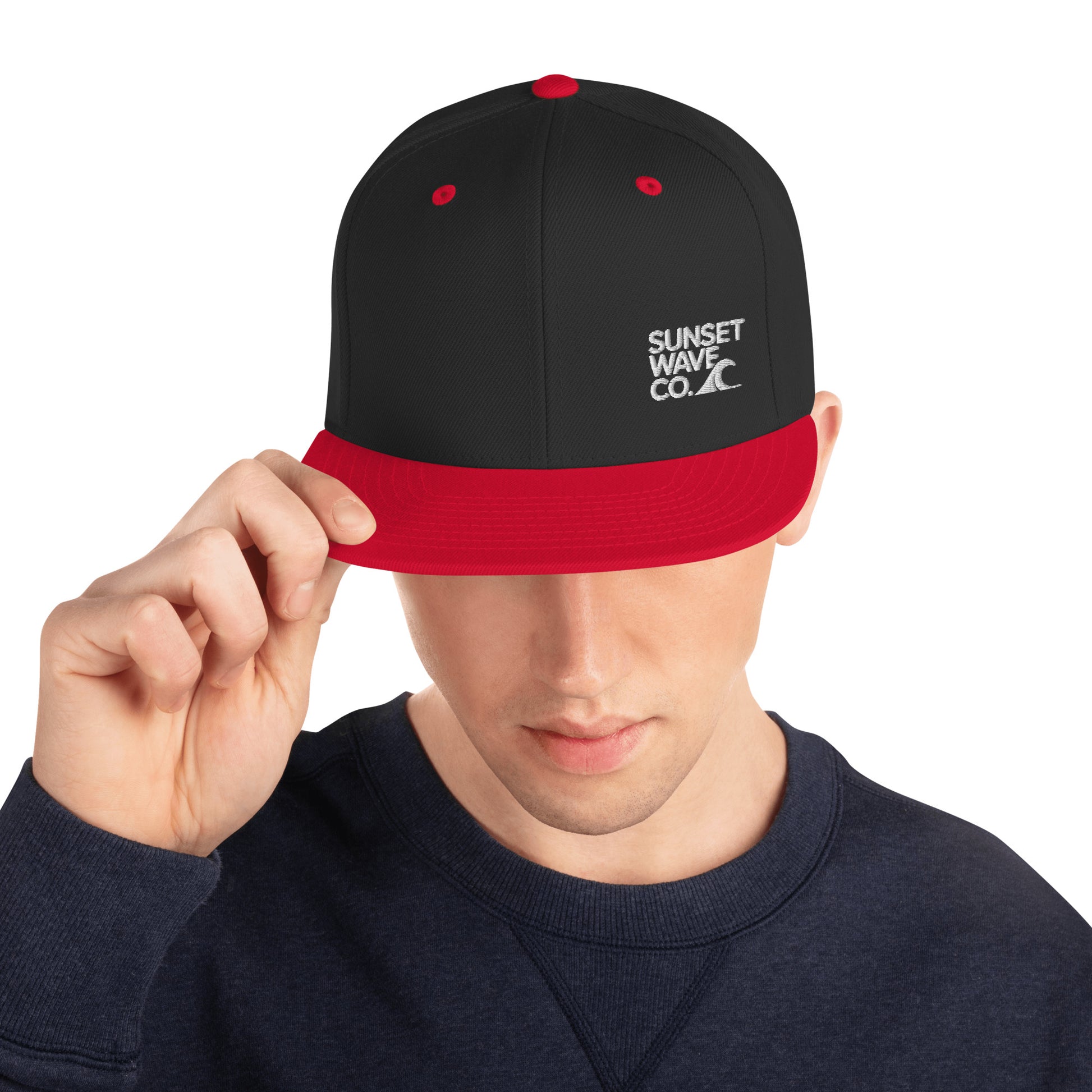 Man wearing black and red classic snapback hat with Sunset Wave Co. logo