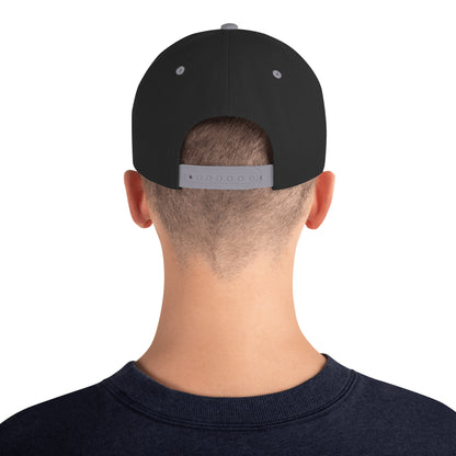 Back view of man wearing black snapback hat with silver adjustable strap and navy shirt