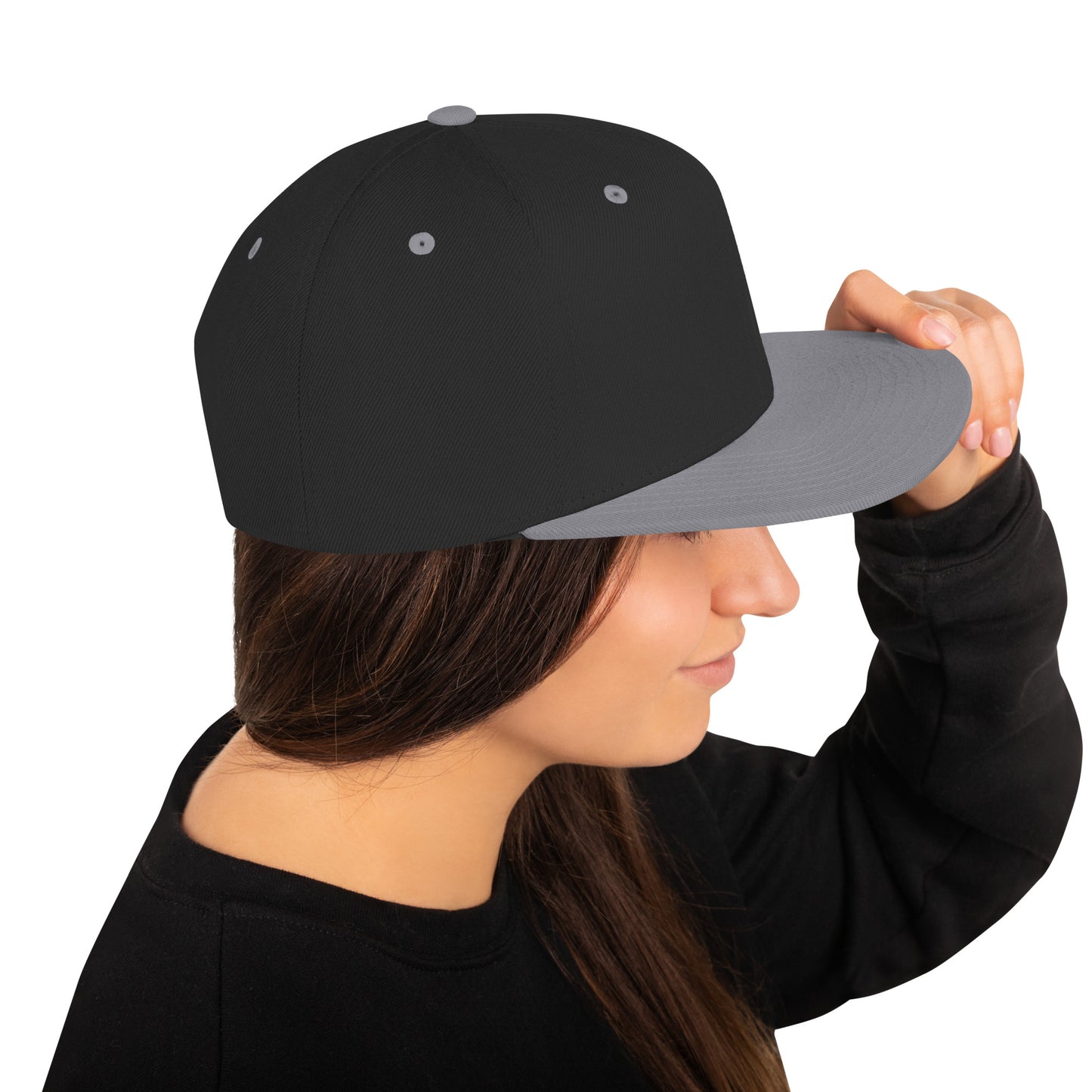 Woman wearing black and silver classic snapback cap holding the brim