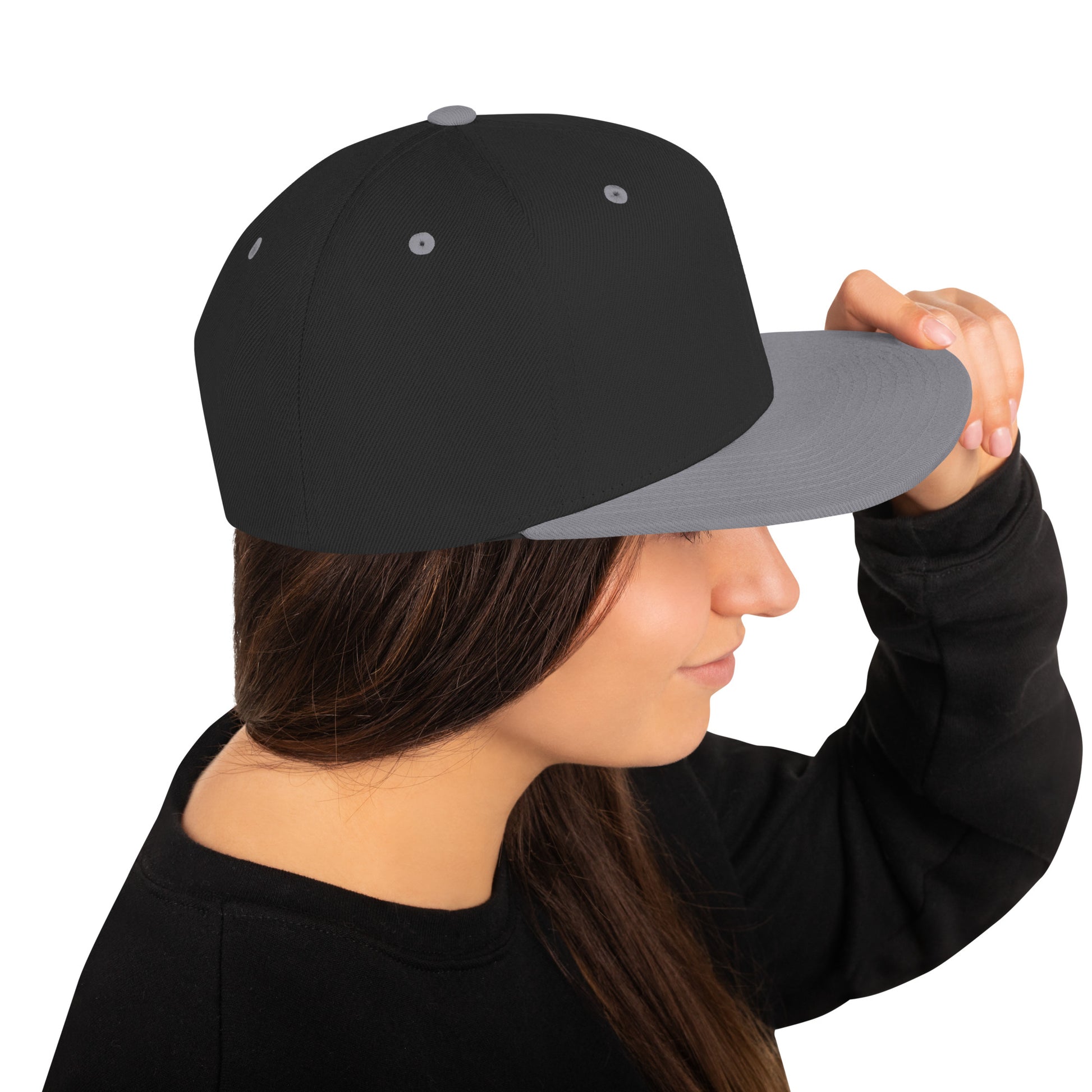 Woman wearing black and silver classic snapback cap holding the brim