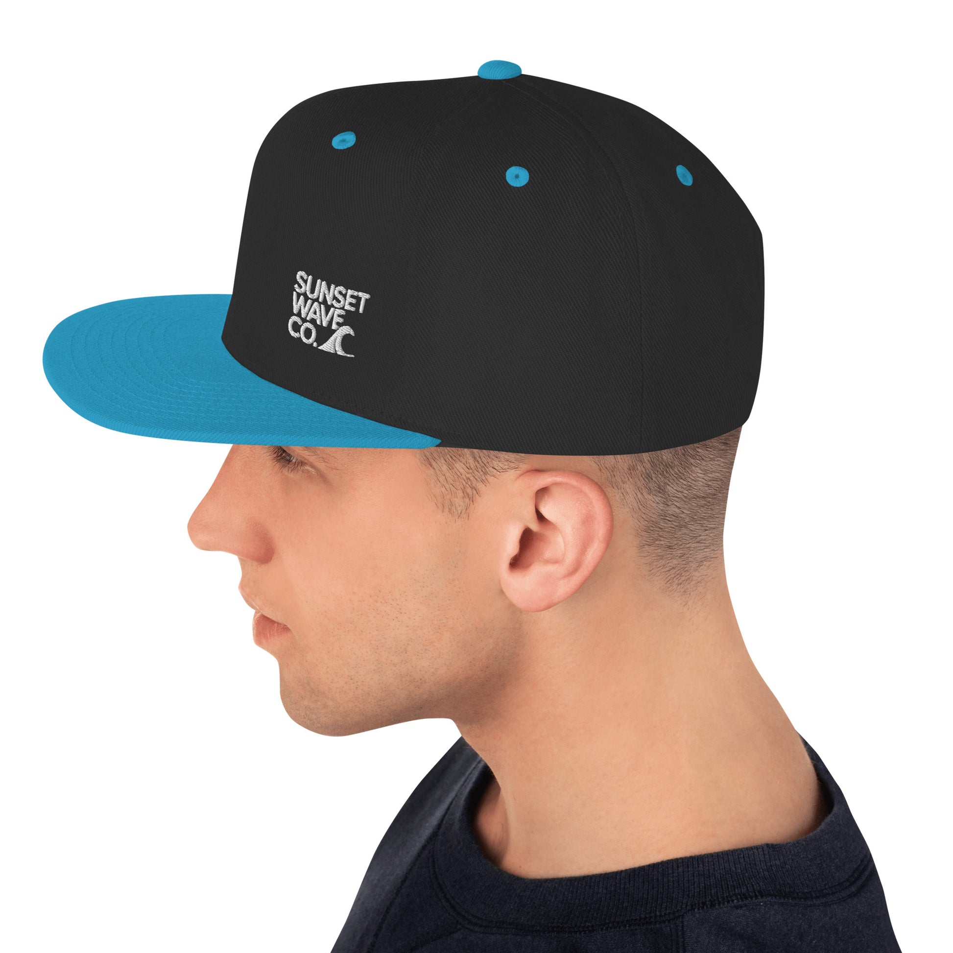 man wearing black snapback cap with teal brim and vents, white Sunset Wave Co logo on side