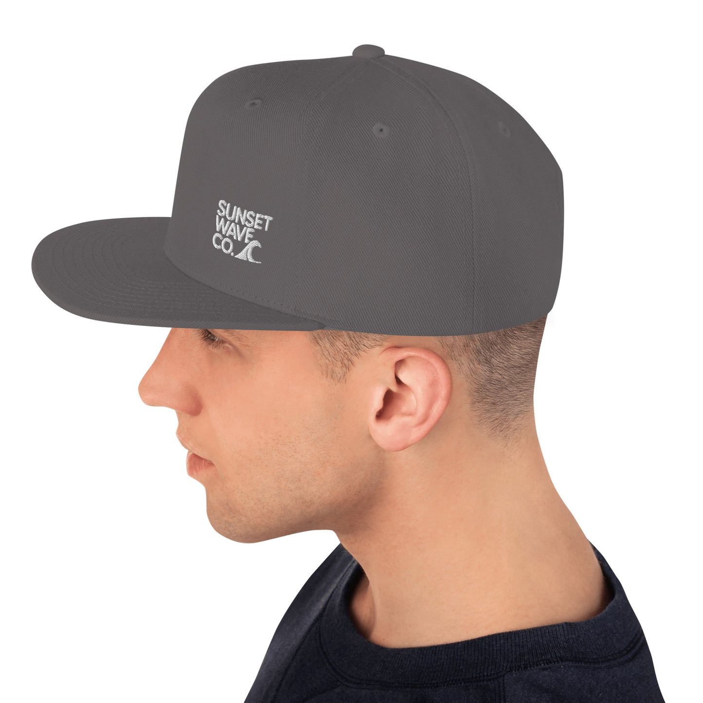 Profile of man wearing dark grey snapback hat with white Sunset Wave Co. logo