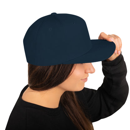 Woman wearing a dark navy classic snapback cap with flat bill, adjusting it with her hand
