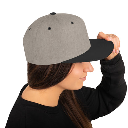 Heather black snapback cap worn by woman with long brown hair and black sweatshirt