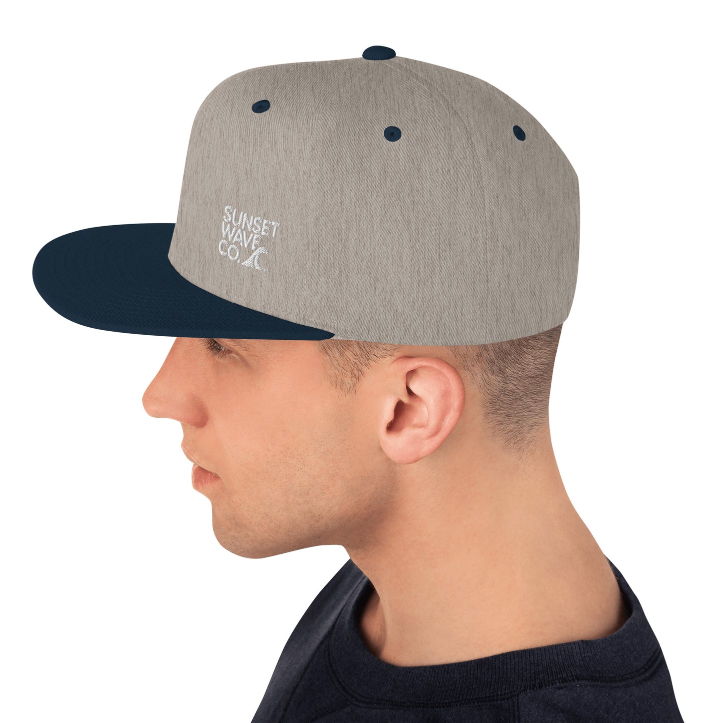 man wearing heather grey and navy snapback hat with Sunset Wave Co embroidered logo