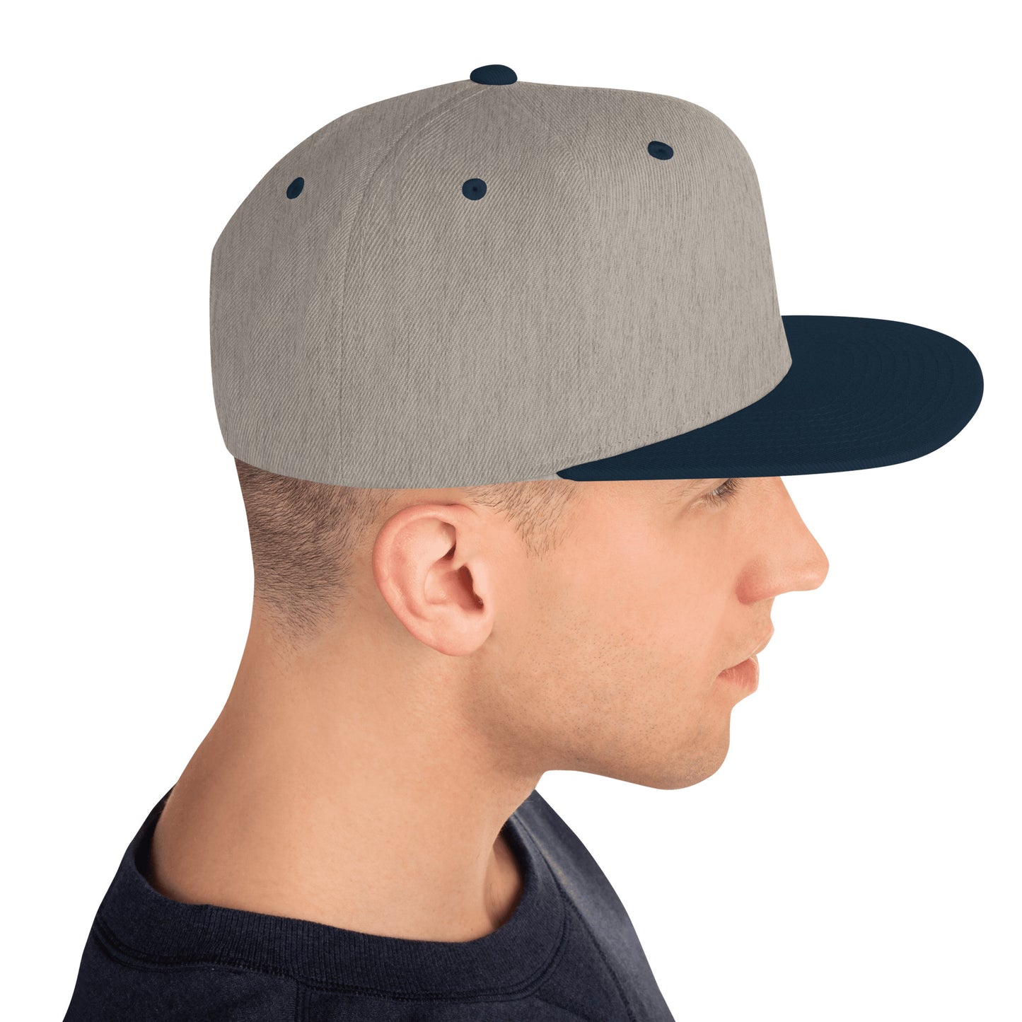 Side view of man wearing heather grey snapback cap with navy blue visor and accents