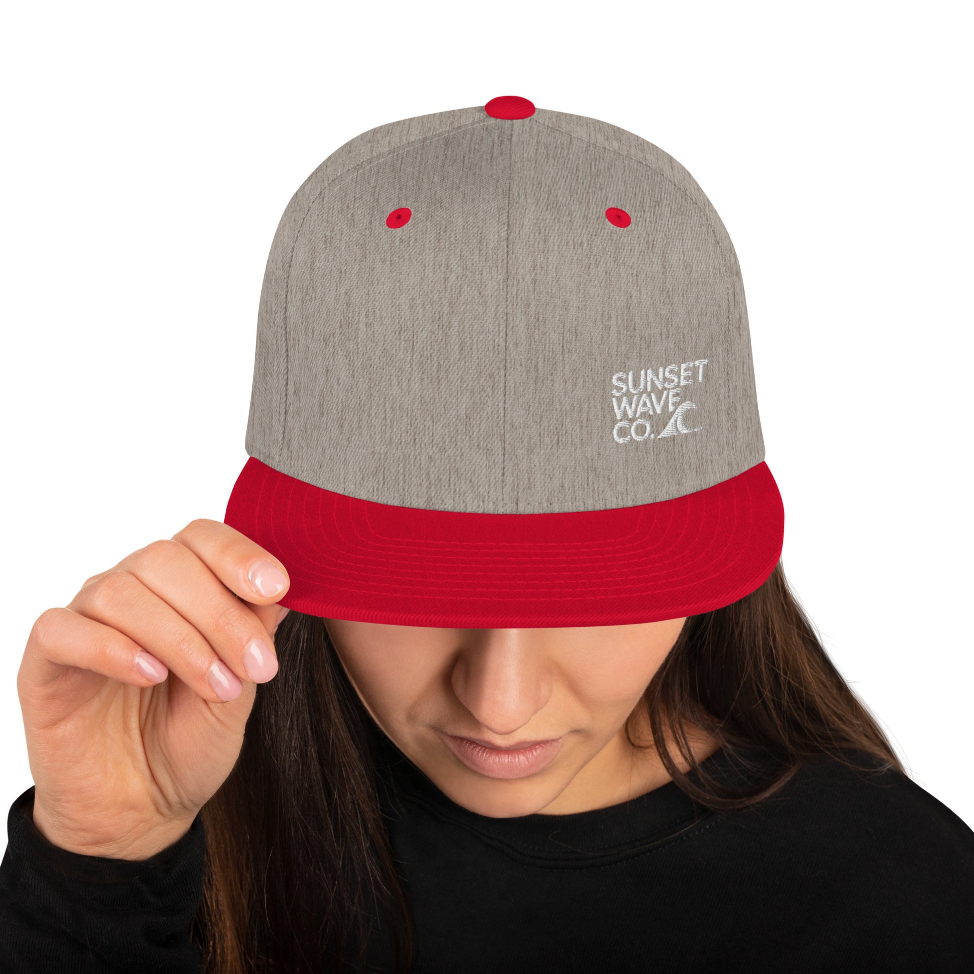 Heather grey and red classic snapback cap with Sunset Wave Co. logo worn by woman in black top