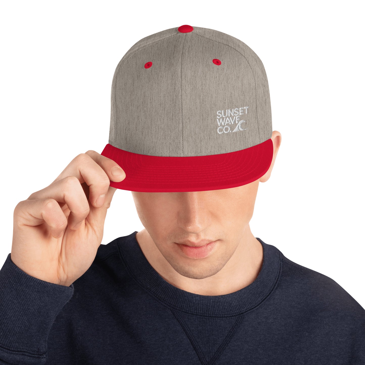 Man wearing heather grey snapback hat with red brim and embroidered Sunset Wave Co. logo