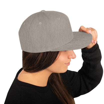 Heather grey classic snapback hat worn by woman in black sweatshirt, side view with hand adjusting brim