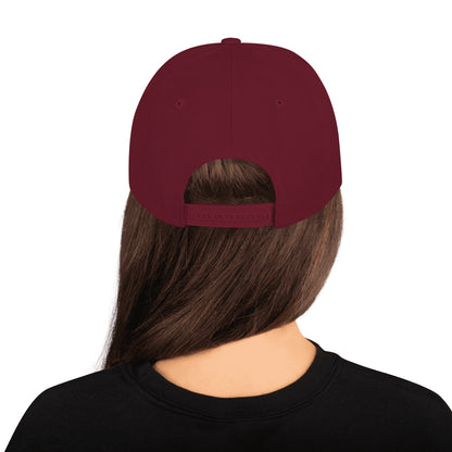 Maroon classic snapback cap worn backwards on woman with long brown hair and black shirt