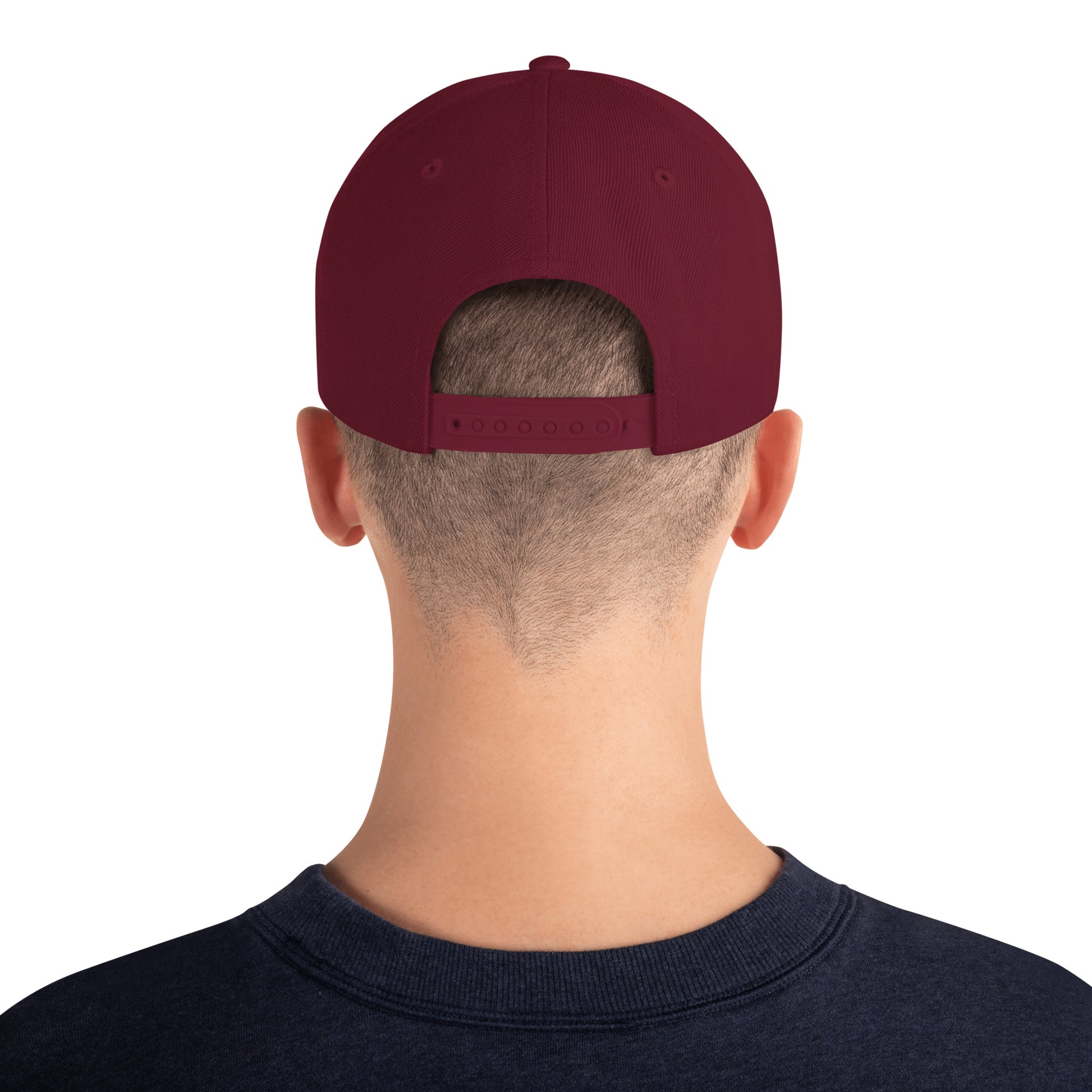 Back view of person wearing maroon classic snapback cap and navy sweatshirt on white background