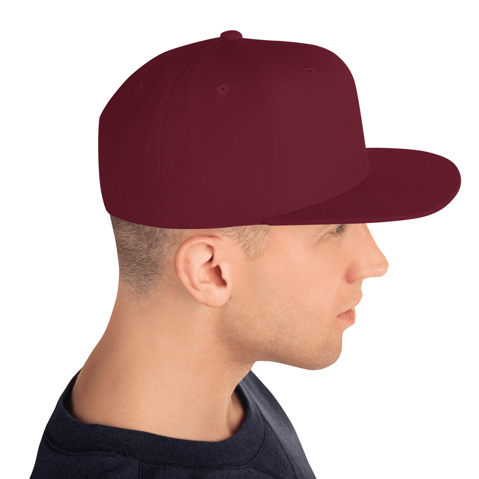 Side view of man wearing maroon classic snapback hat and dark shirt on white background