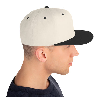 Side view of man wearing natural beige snapback cap with black brim and button
