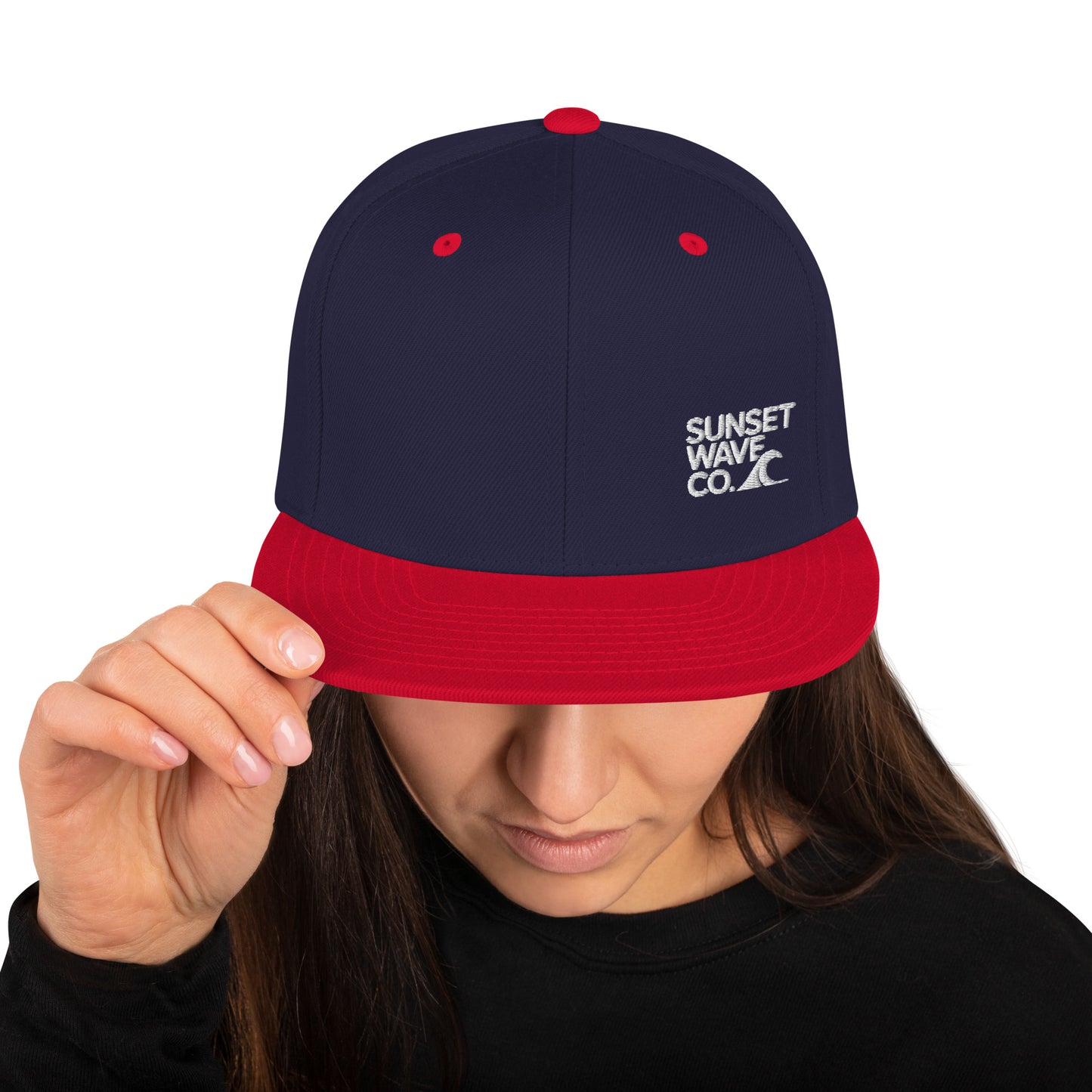 Woman wearing navy blue and red snapback hat with Sunset Wave Co. logo embroidered