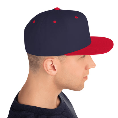 Profile of man wearing classic navy snapback hat with bright red brim and eyelets