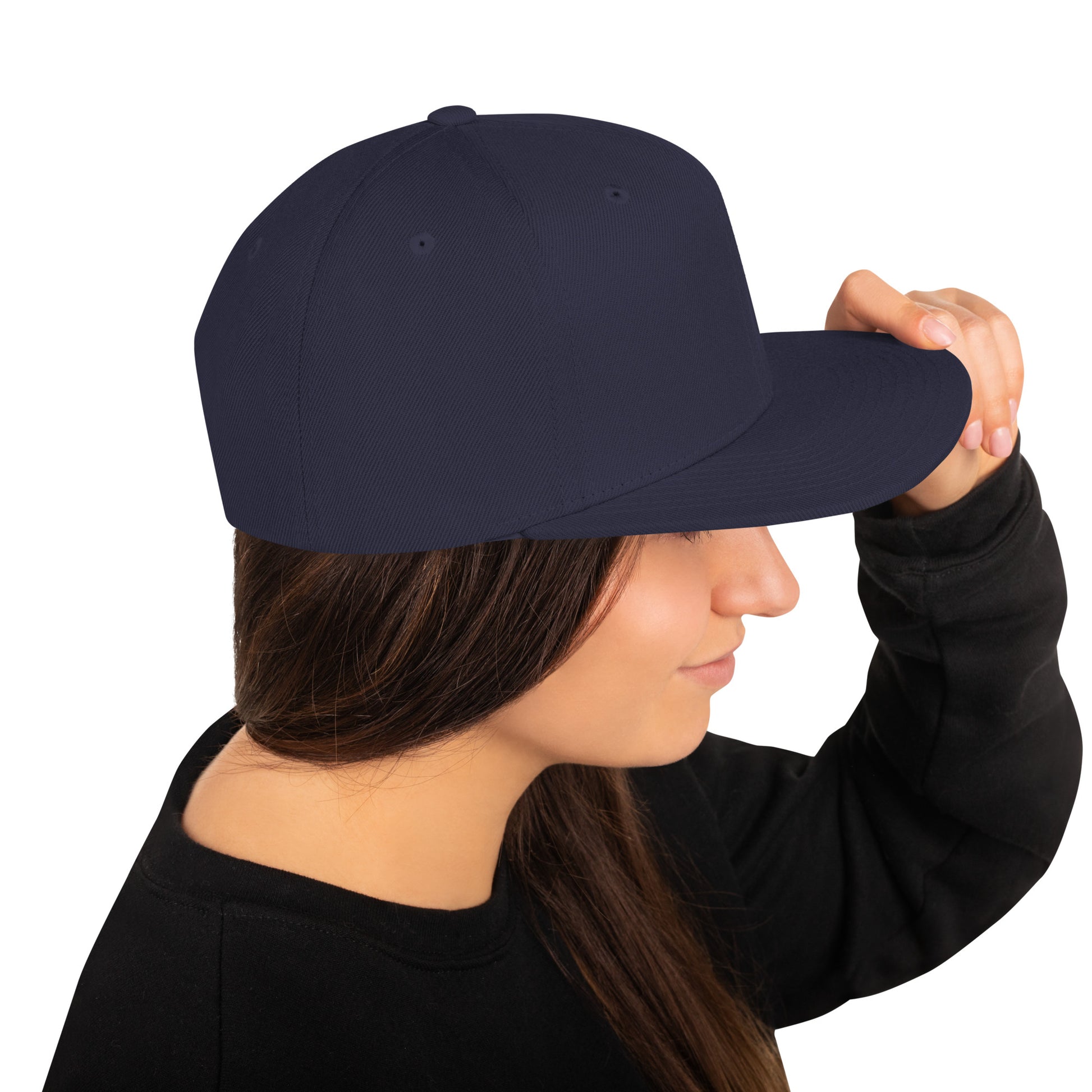 Woman wearing a classic navy snapback cap sideways with black sweatshirt, isolated on white