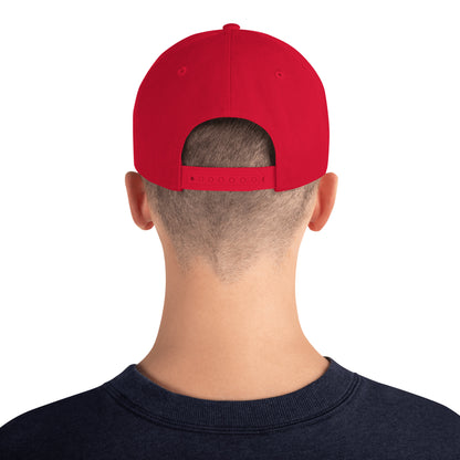 Back view of person wearing a red classic snapback hat and navy blue shirt on white background