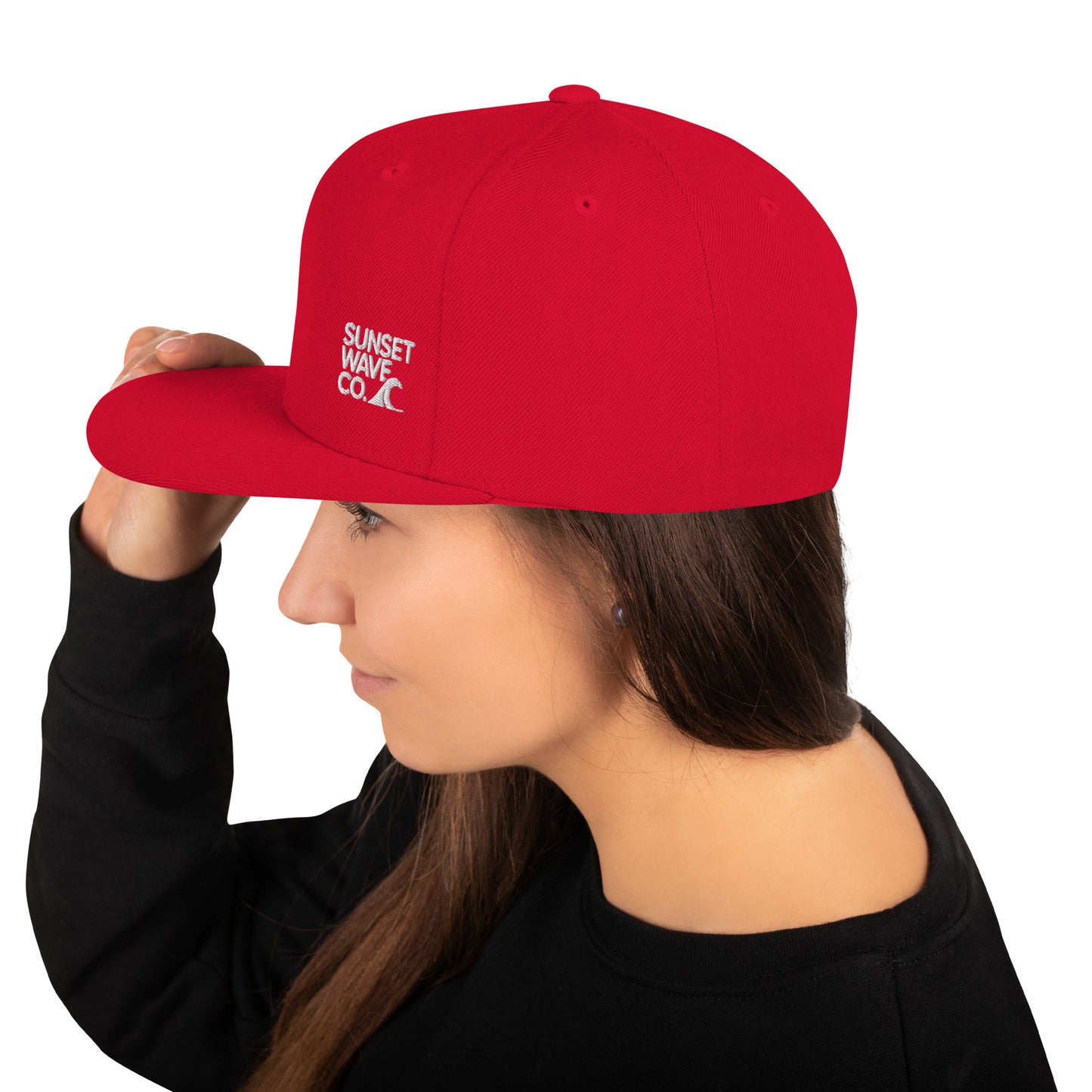 Woman wearing red classic snapback cap with white Sunset Wave Co. logo, black shirt