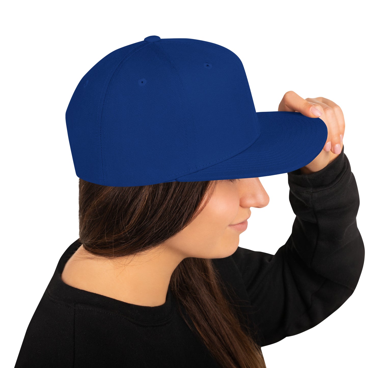 Side view of person wearing royal blue classic snapback hat and black sweatshirt holding the brim
