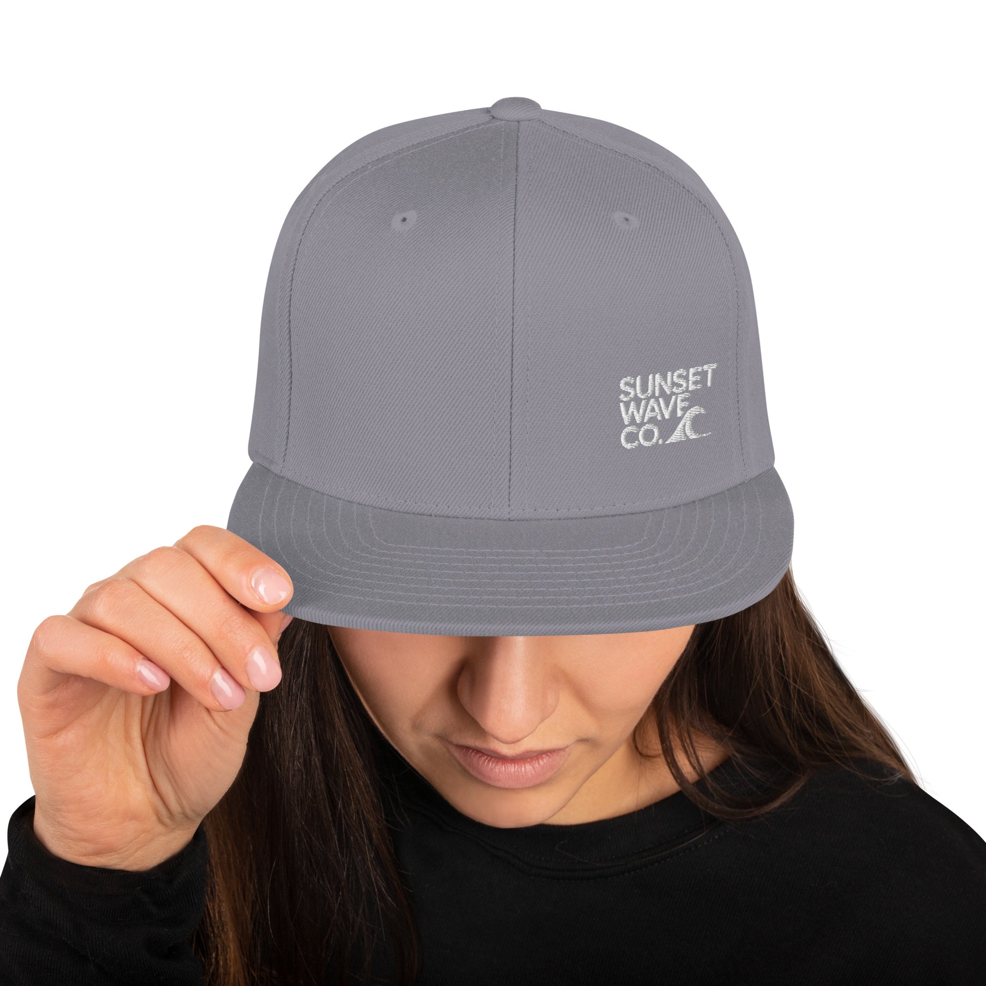 Woman wearing gray classic snapback cap with white Sunset Wave Co. logo