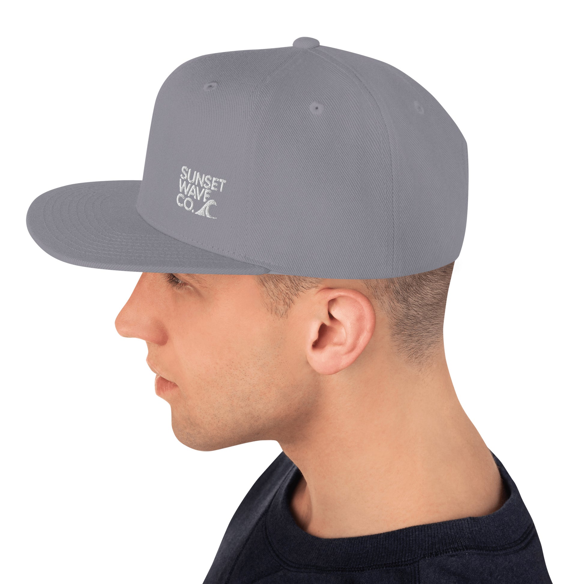 Side view of man wearing silver classic snapback cap with Sunset Wave Co. logo