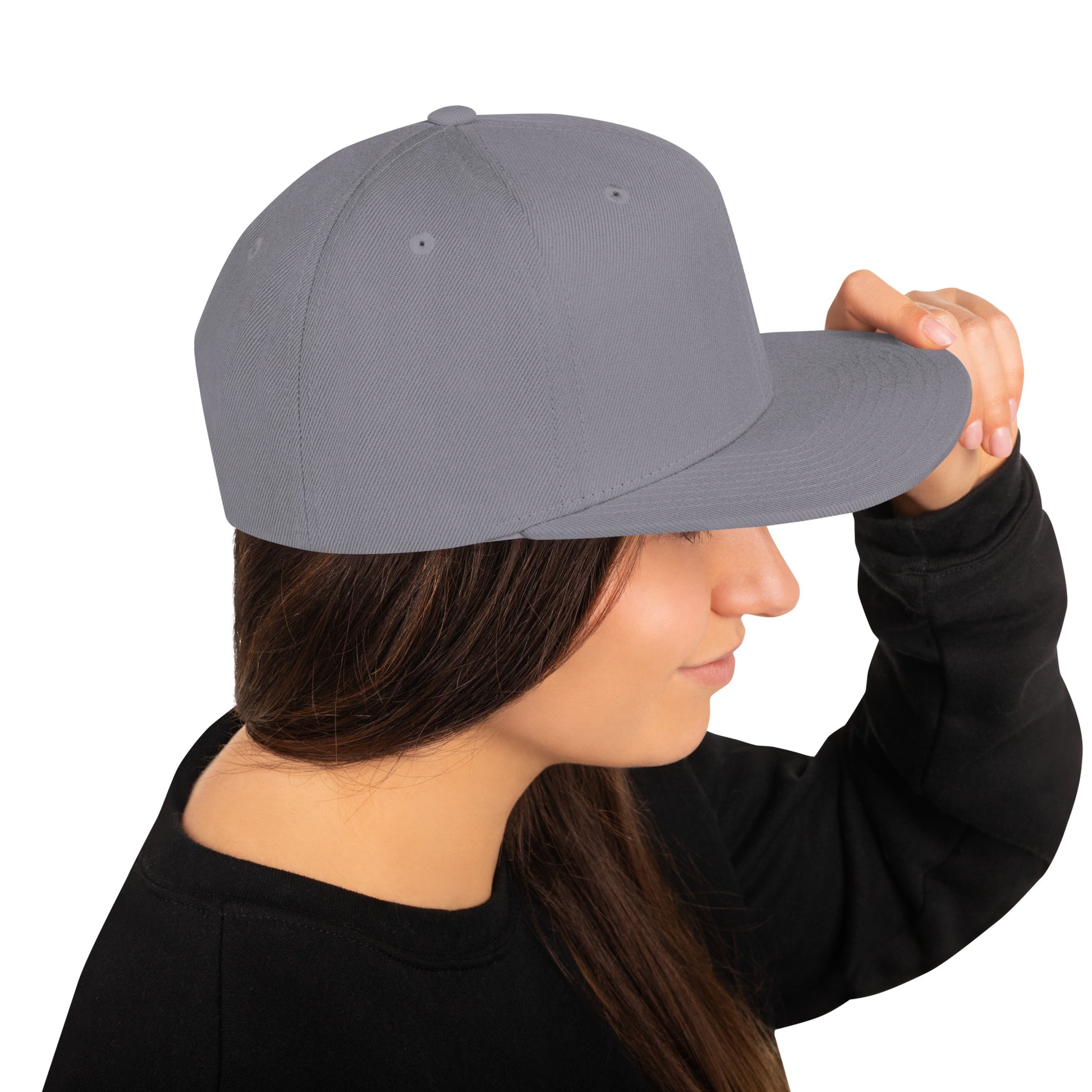 Woman wearing a classic silver snapback cap with flat brim, holding the brim with her hand