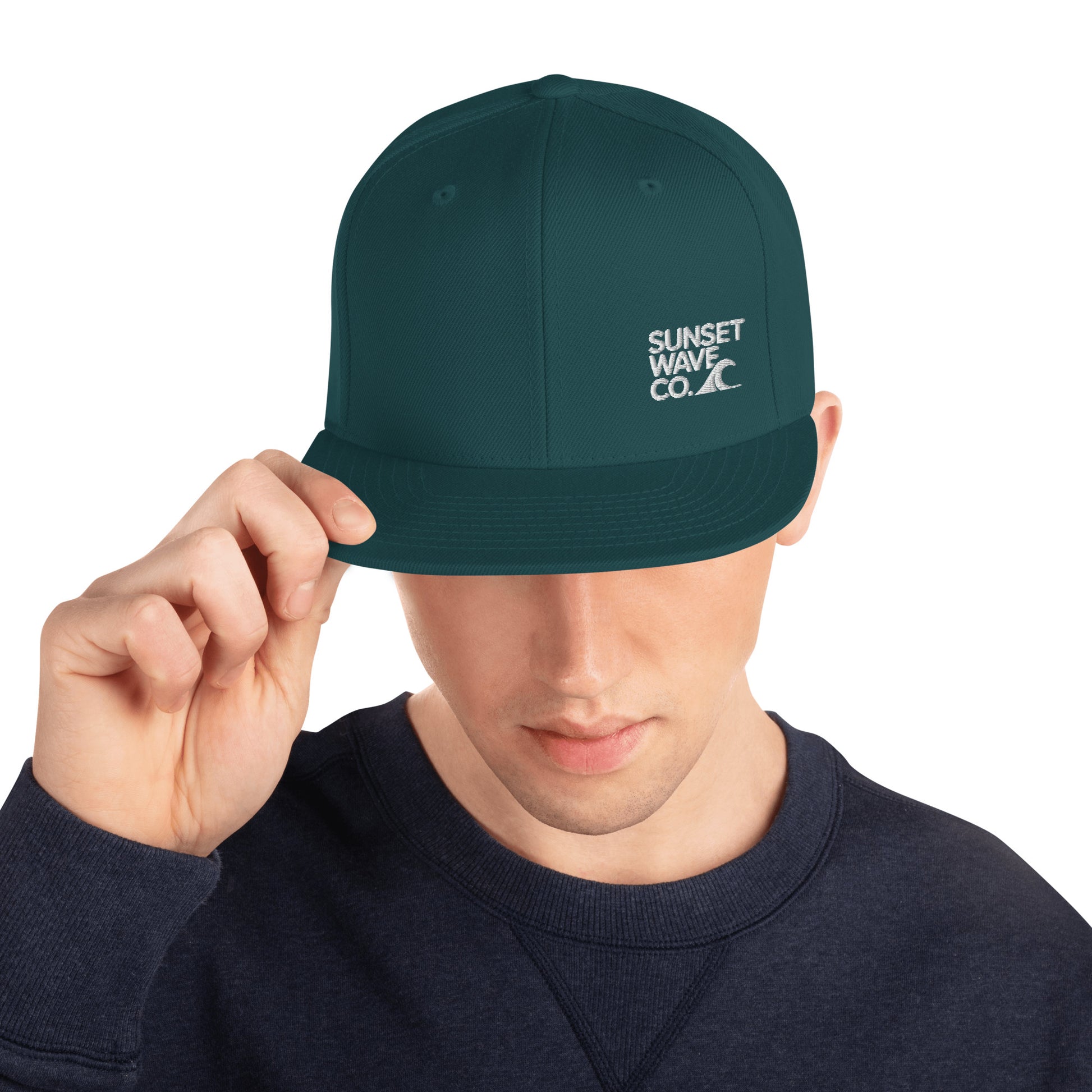 Man wearing spruce green classic snapback hat with Sunset Wave Co. embroidered logo