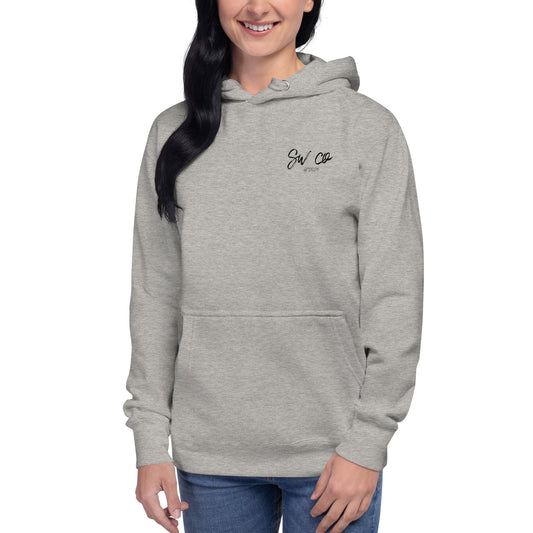 Woman wearing carbon grey unisex pullover hoodie with front pocket and small chest logo