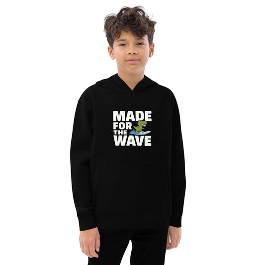 Boy wearing black fleece hoodie with dinosaur and surfing graphic saying Made for the Wave