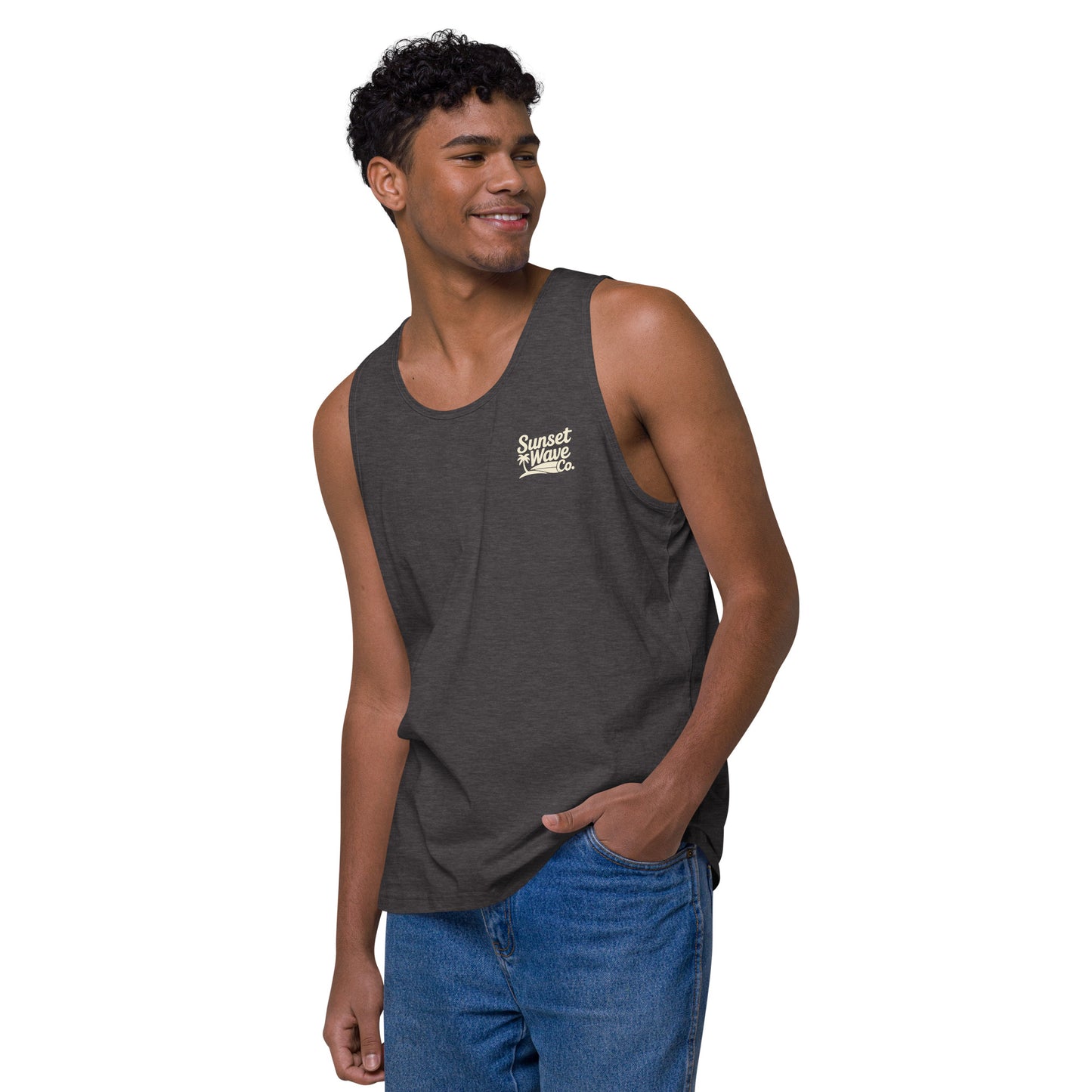 smiling man wearing charcoal heather men's premium tank top with Sunset Wave Co. logo and blue jeans
