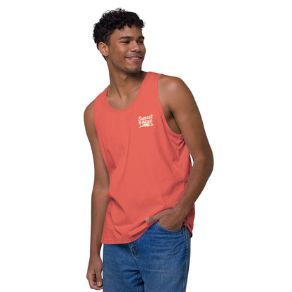 Smiling young man wearing coral tank top with Sunset Wave Co. logo and blue jeans on white background