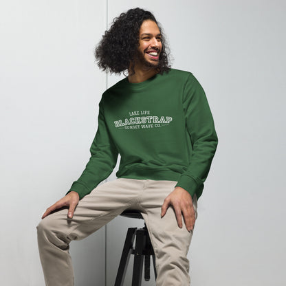 Man wearing unisex organic bottle green sweatshirt with white Blackstrap logo sitting on stool