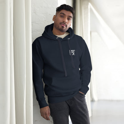 Man wearing navy blue unisex premium hoodie with front pocket and white text logo standing indoors