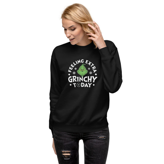 Woman wearing black sweatshirt with green Grinch and text "Feeling extra grinchy today" on white background