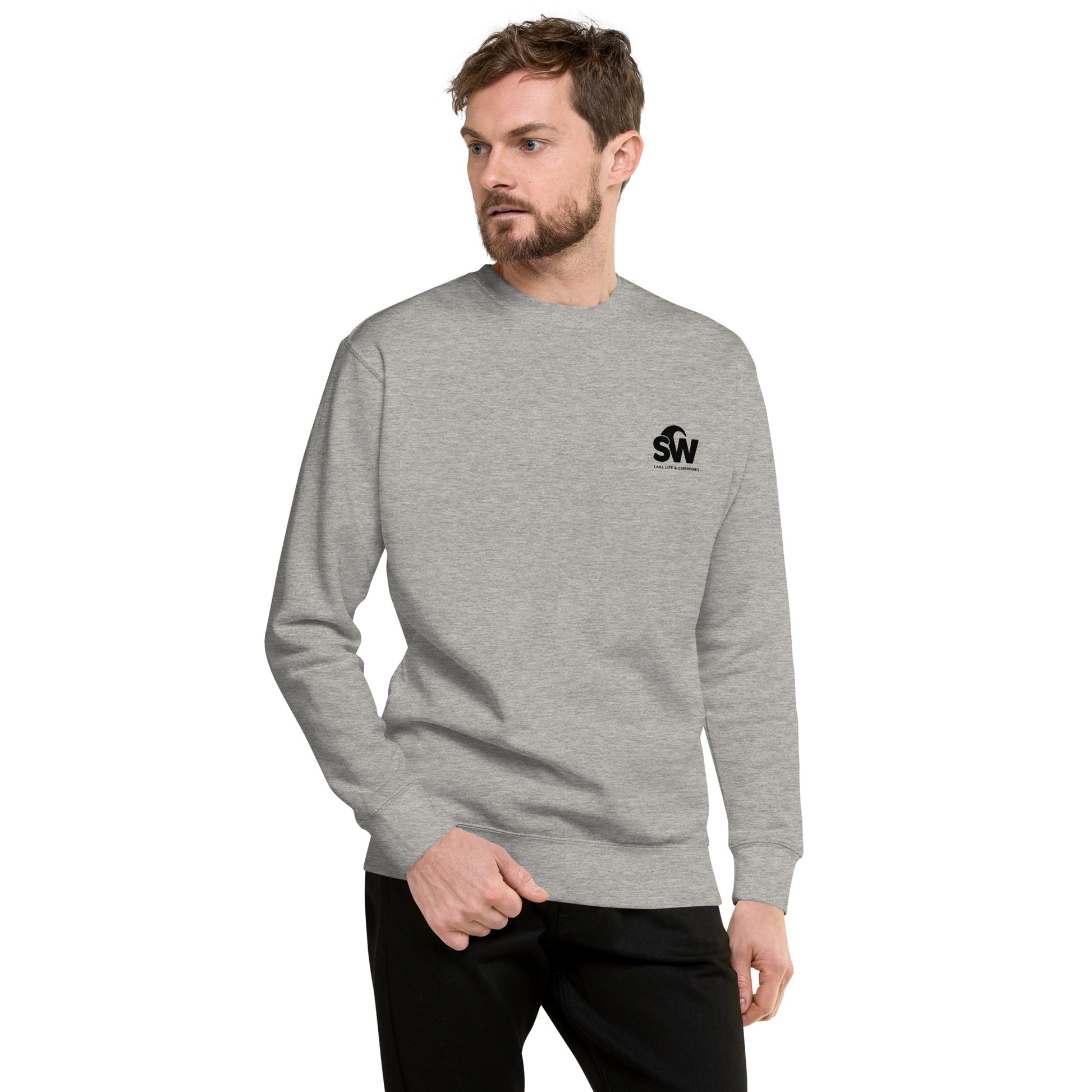 Man wearing unisex premium light grey sweatshirt with black logo on chest, paired with black pants