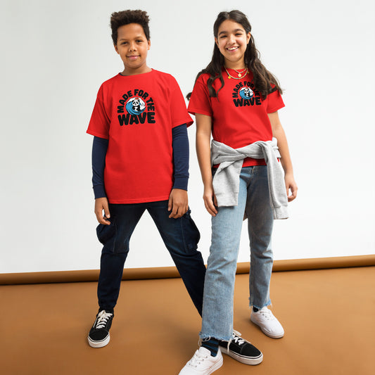 Two kids wearing red "Made For The Wave" graphic tees with jeans and sneakers on a brown and white studio backdrop